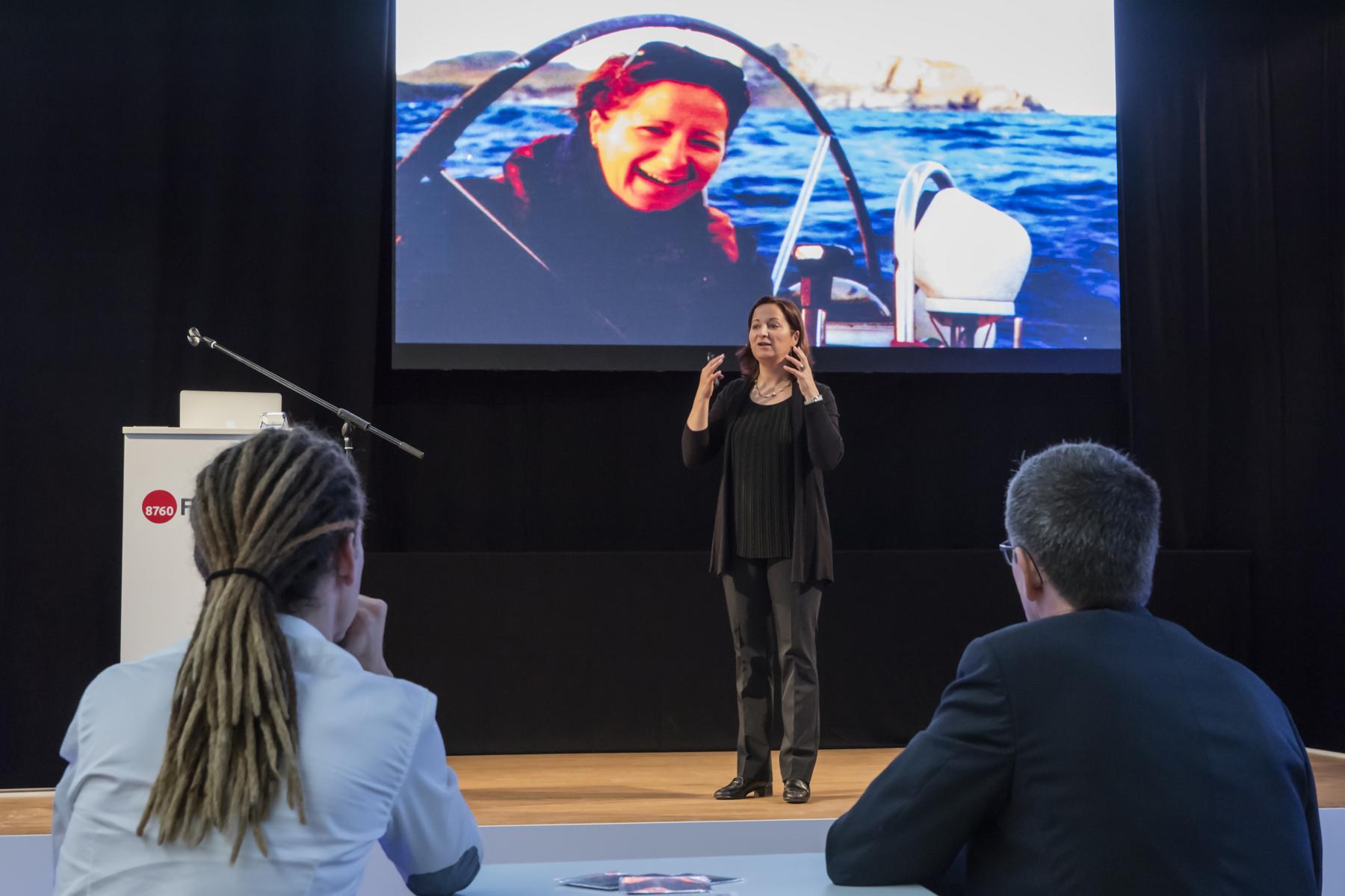 Stefanie Voss Keynote Führung – auf der Bühne, im Hintergrund ihre Weltumsegelung auf der Leinwand